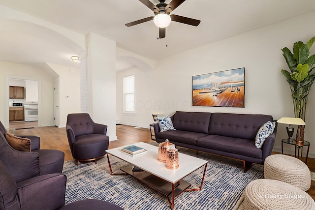 1361 City Park Ave, Columbus, OH 43207 - living room featuring arched walkways, a ceiling fan, and wood finished floors