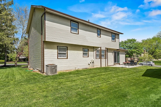 rear view of house featuring a lawn, a patio area, and central air condition unit
