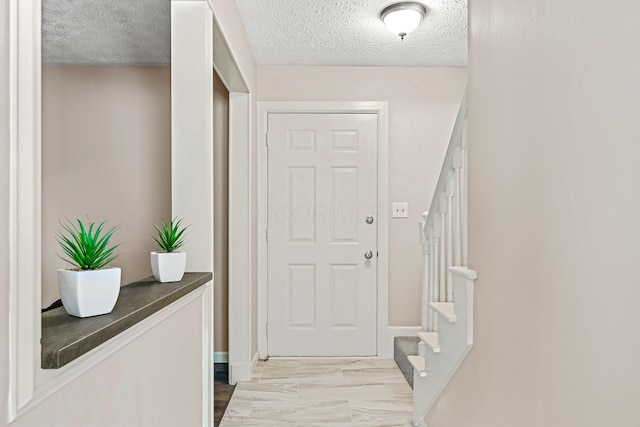 doorway to outside featuring stairs and a textured ceiling