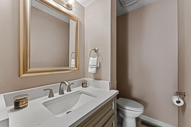 half bath featuring vanity, visible vents, and toilet