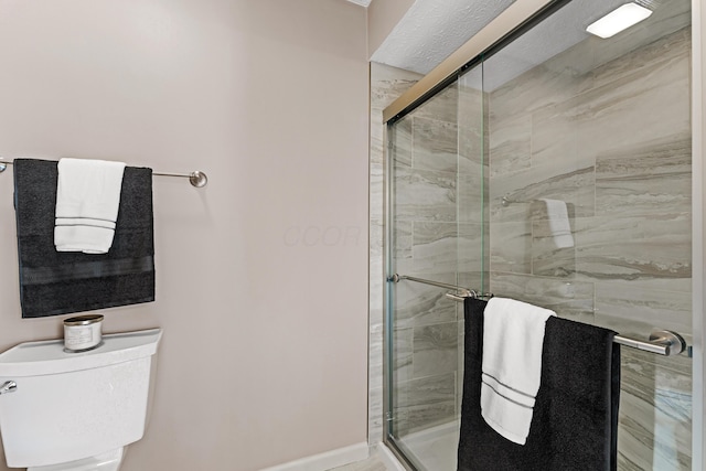 full bathroom featuring a stall shower and toilet