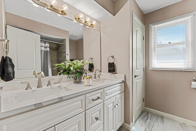 bathroom with baseboards, a sink, marble finish floor, and double vanity