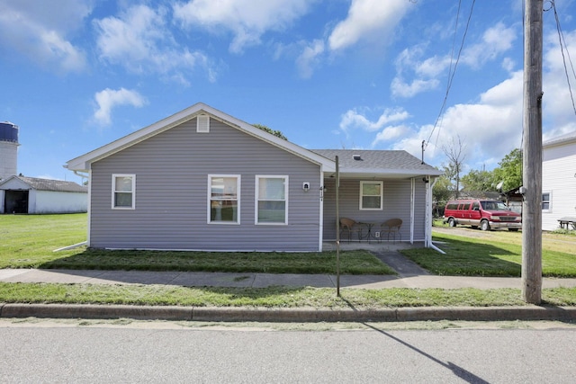 view of front of property with a shingled roof and a front lawn