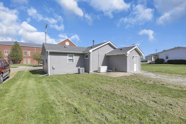 rear view of house featuring a lawn, a patio area, and central AC