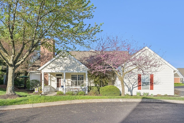 view of front of house with covered porch and a chimney