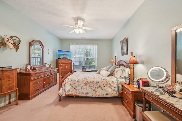 bedroom featuring multiple windows, light carpet, a ceiling fan, and a textured ceiling