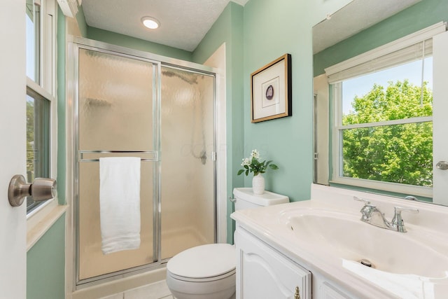 bathroom featuring vanity, a textured ceiling, a stall shower, and toilet