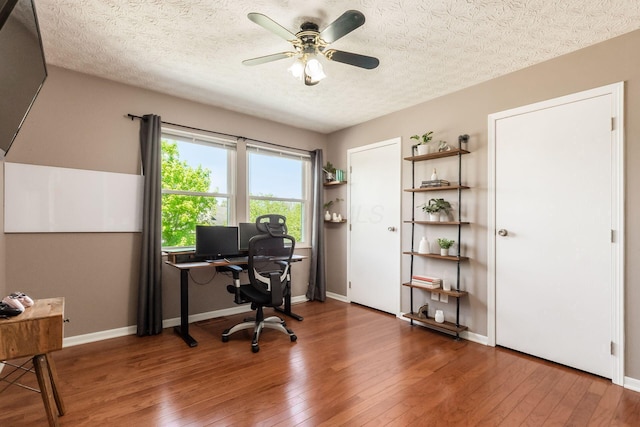 office space with baseboards, a ceiling fan, and hardwood / wood-style floors