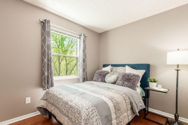 bedroom with baseboards and wood finished floors