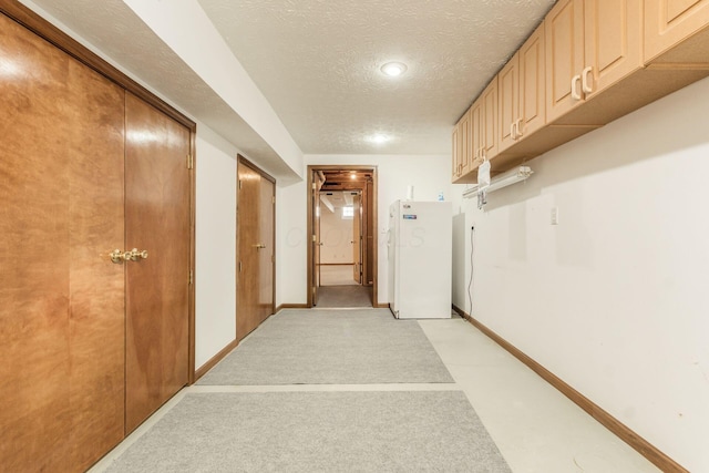 corridor with baseboards and a textured ceiling