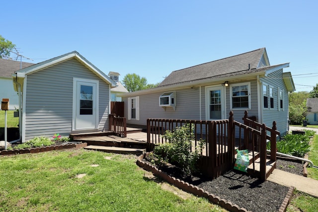 back of house with a yard, a deck, and an outdoor structure