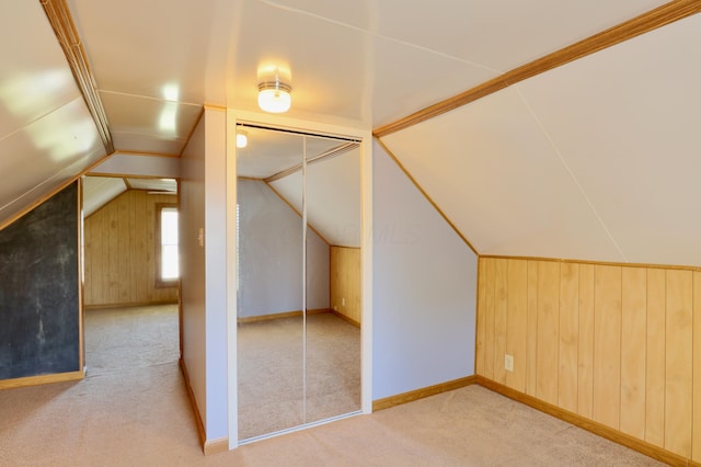 bonus room featuring carpet flooring, wood walls, and lofted ceiling