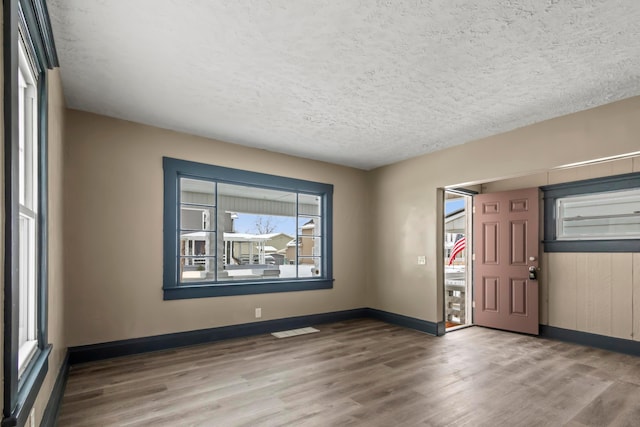 entrance foyer featuring baseboards, a textured ceiling, and wood finished floors