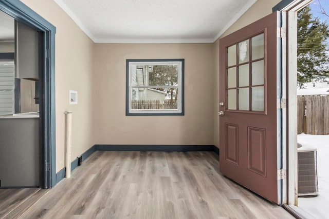 doorway to outside with baseboards, ornamental molding, and wood finished floors
