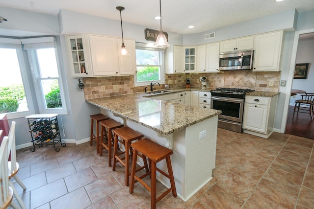 kitchen with a wealth of natural light, stainless steel appliances, baseboards, and visible vents