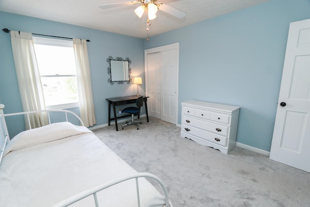 bedroom featuring baseboards, light carpet, a closet, and a ceiling fan