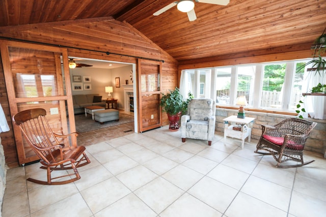 living area with vaulted ceiling, ceiling fan, wooden walls, and wood ceiling