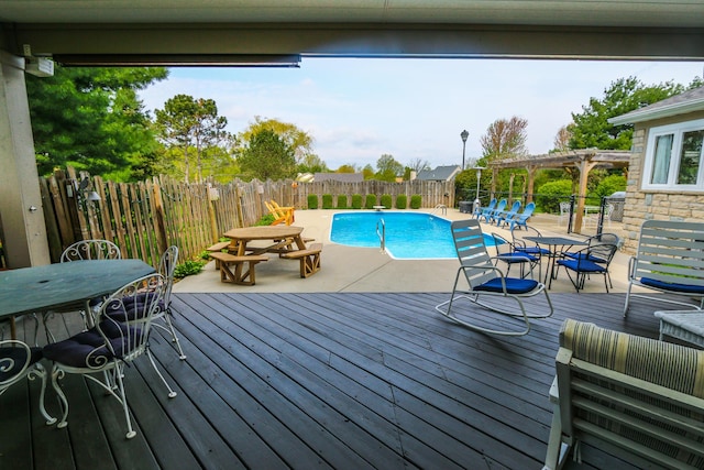 view of swimming pool with a pergola, a wooden deck, outdoor dining area, and a fenced in pool