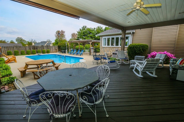 view of pool with fence, a deck, a pergola, ceiling fan, and a fenced in pool