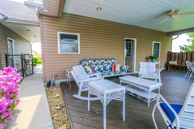 deck with a ceiling fan, an outdoor living space, and fence