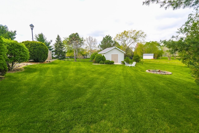 view of yard with a fire pit and an outbuilding