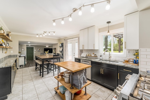 kitchen featuring crown molding, open shelves, dark cabinets, a sink, and light tile patterned floors