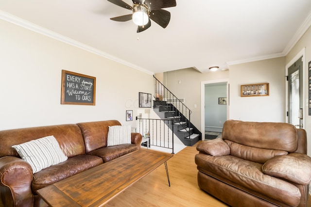 living room with light wood-style floors, crown molding, stairway, and ceiling fan