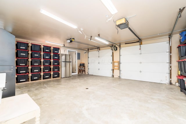 garage featuring a garage door opener and freestanding refrigerator