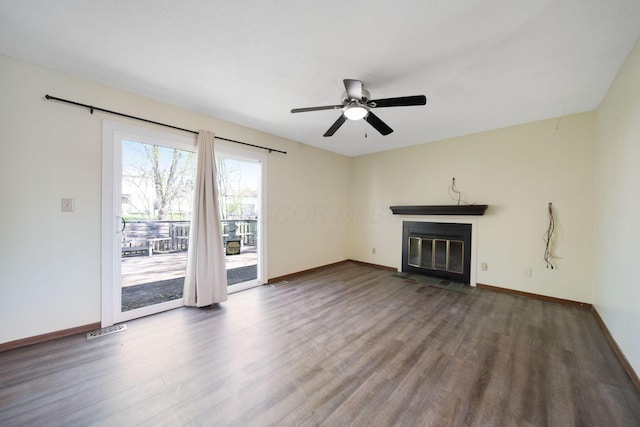 unfurnished living room with baseboards, a fireplace with flush hearth, and wood finished floors
