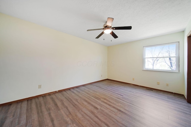 unfurnished room featuring a ceiling fan, baseboards, and wood finished floors