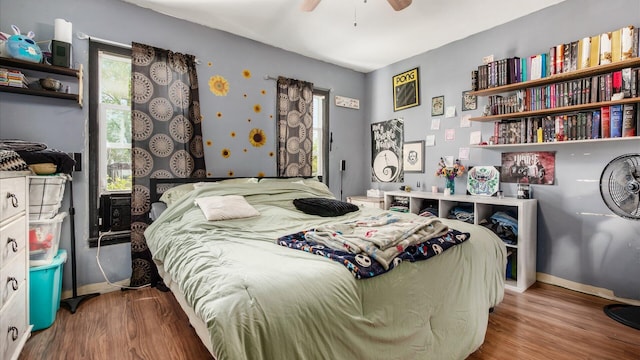 bedroom with baseboards, a ceiling fan, and wood finished floors