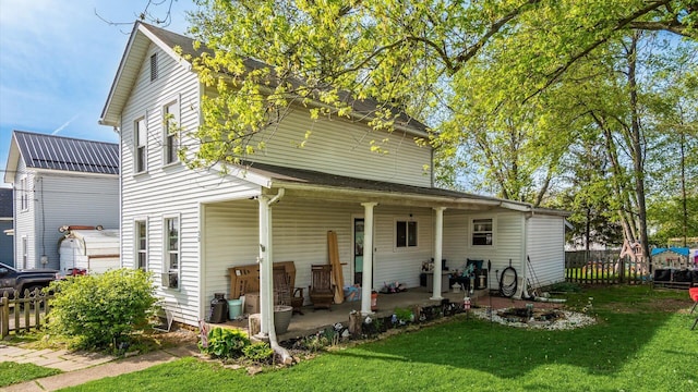 back of property featuring a lawn and fence