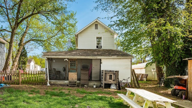 back of house with roof with shingles, fence, and entry steps