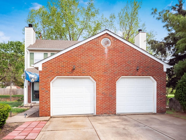 view of side of home featuring brick siding, driveway, a chimney, and roof with shingles