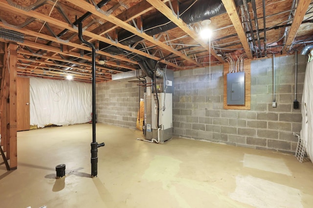 unfinished basement featuring heating unit, concrete block wall, and electric panel