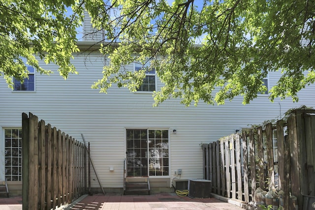 rear view of property with fence and a patio area