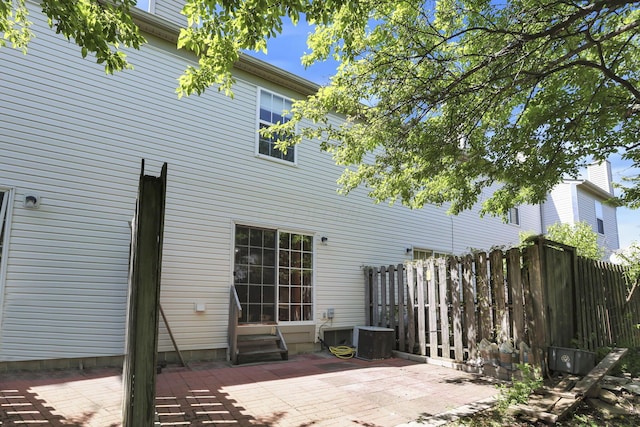 back of house with entry steps, fence, and a patio area