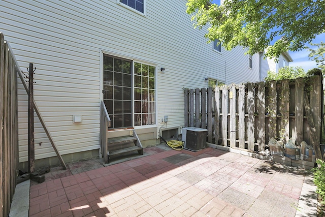view of patio / terrace with central AC, fence, and entry steps