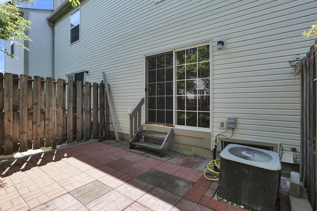 view of patio featuring entry steps, fence, and central AC