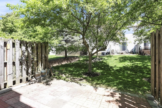 view of yard with fence and a patio