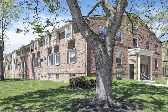 view of side of home with a lawn and brick siding