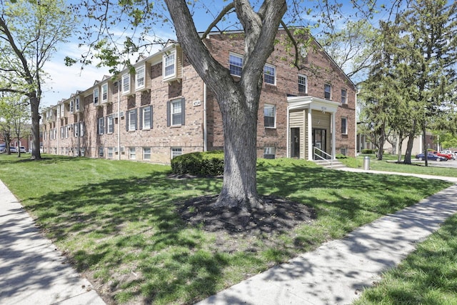 view of front of property featuring a front lawn and brick siding