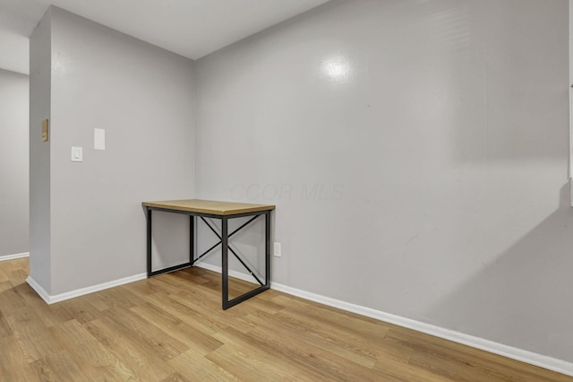 unfurnished room featuring baseboards and light wood-type flooring