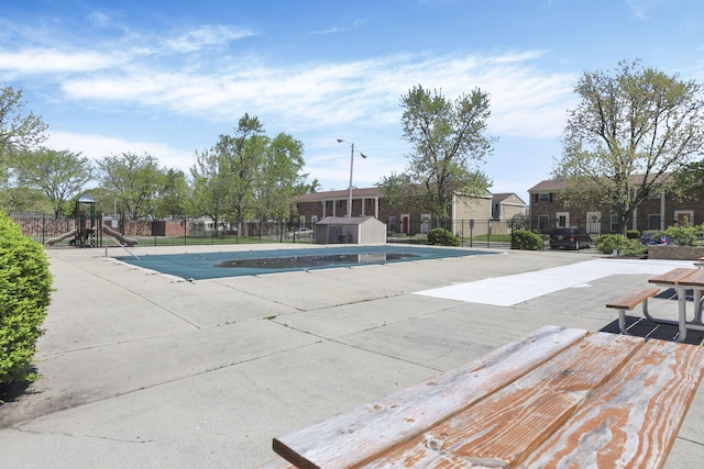 view of swimming pool with a fenced in pool, fence, an outdoor structure, and a storage unit