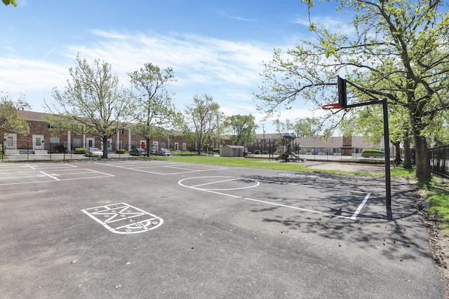 view of sport court featuring fence, community basketball court, and playground community