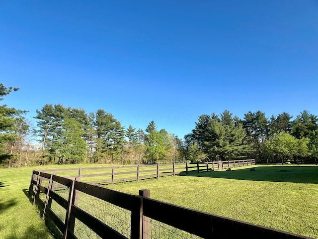 view of yard with a rural view and fence