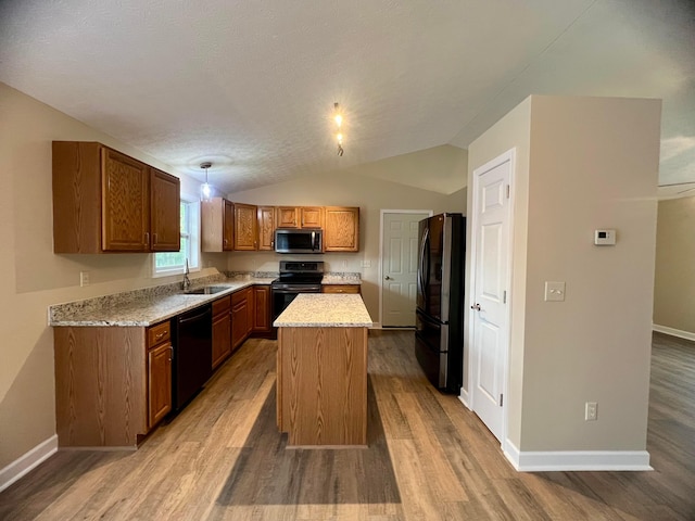 357 Carroll Eastern Rd NW, Baltimore, OH 43105 - kitchen featuring a sink, brown cabinetry, light wood-style flooring, and black appliances