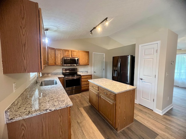 357 Carroll Eastern Rd NW, Baltimore, OH 43105 - kitchen with a sink, brown cabinets, light wood-style floors, and appliances with stainless steel finishes