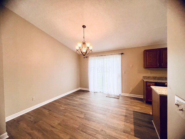 357 Carroll Eastern Rd NW, Baltimore, OH 43105 - unfurnished dining area with a textured ceiling, a notable chandelier, baseboards, and dark wood finished floors