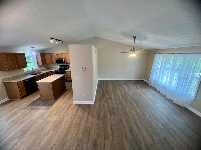 357 Carroll Eastern Rd NW, Baltimore, OH 43105 - kitchen featuring a textured ceiling, black appliances, vaulted ceiling, open floor plan, and a kitchen island